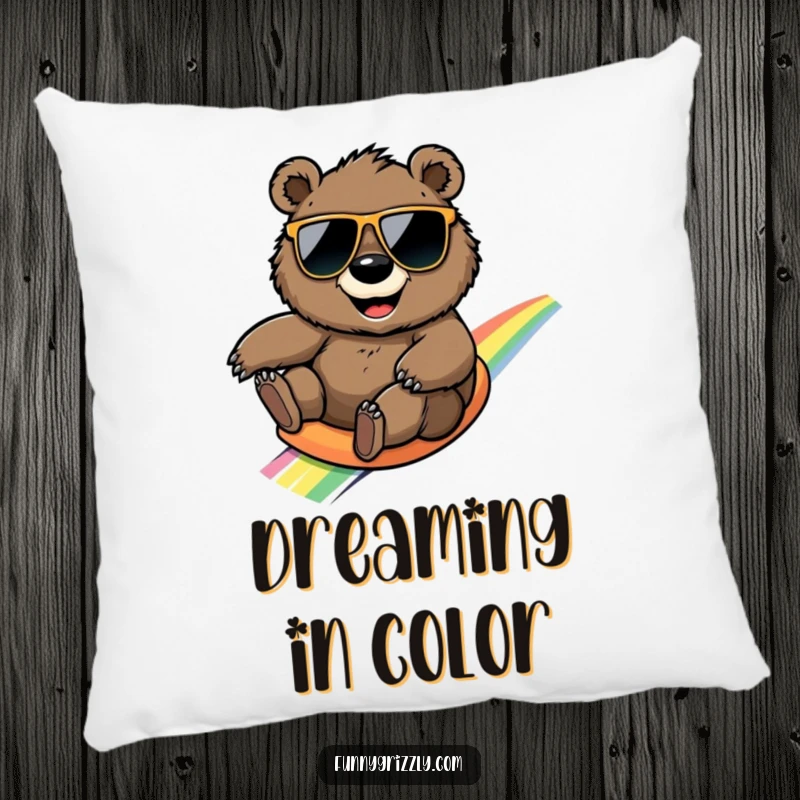 Funny round grizzly bear with sunglasses slides down a rainbow, featured on a plush and humorous pillow.