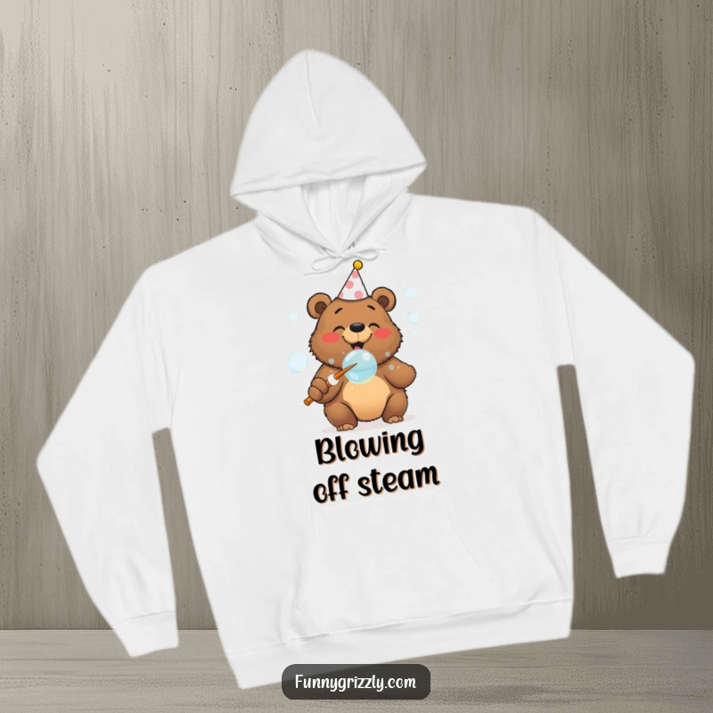 Funny cheerful grizzly bear in a party hat blowing bubbles with a huge wand, featured on a cozy hoodie.