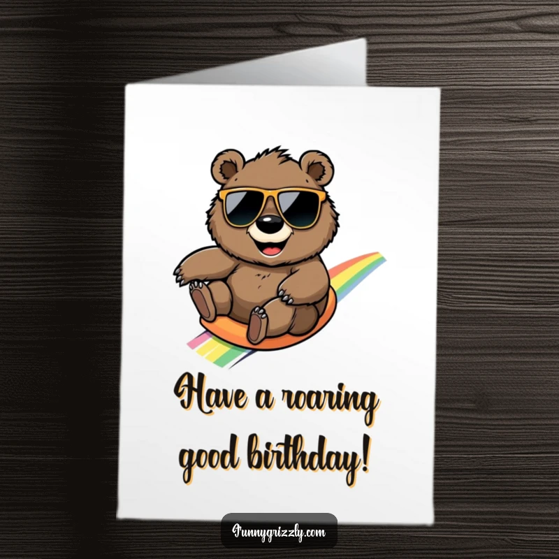 Funny Free Printable Birthday Card: Smiling grizzly bear in sunglasses sliding down a rainbow, birthday joy.
