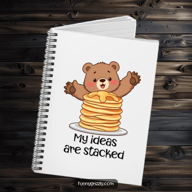 Funny notebook with a grizzly bear attempting to balance on a wobbling stack of pancakes, perfect for jotting notes humorously.