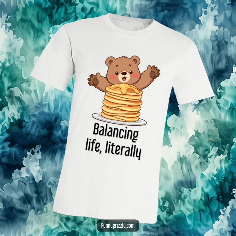 Funny t-shirt featuring a grizzly bear attempting to balance on a wobbling stack of pancakes, depicting a humorous and precarious situation.