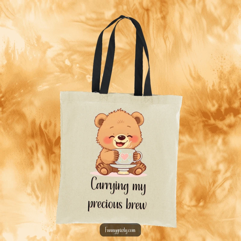 Funny tote bag showcasing a giggling grizzly bear cub attempting to balance a teacup on its fuzzy head.