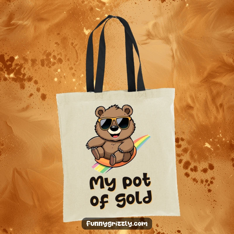 Funny round grizzly bear wearing sunglasses, sliding down a rainbow on a spacious and humorous tote bag.